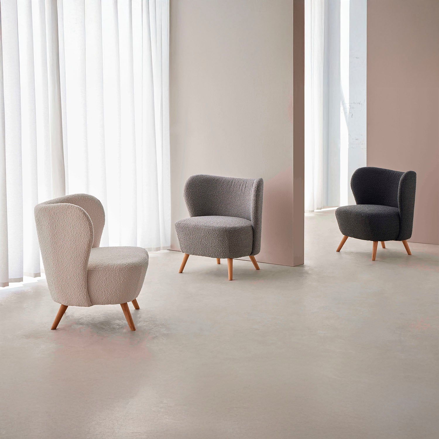 Sillón tapizado en color blanco con patas de madera.