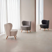 Sillón tapizado en color blanco con patas de madera.