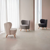 Jaipur armchair in bouclé with wooden legs.
